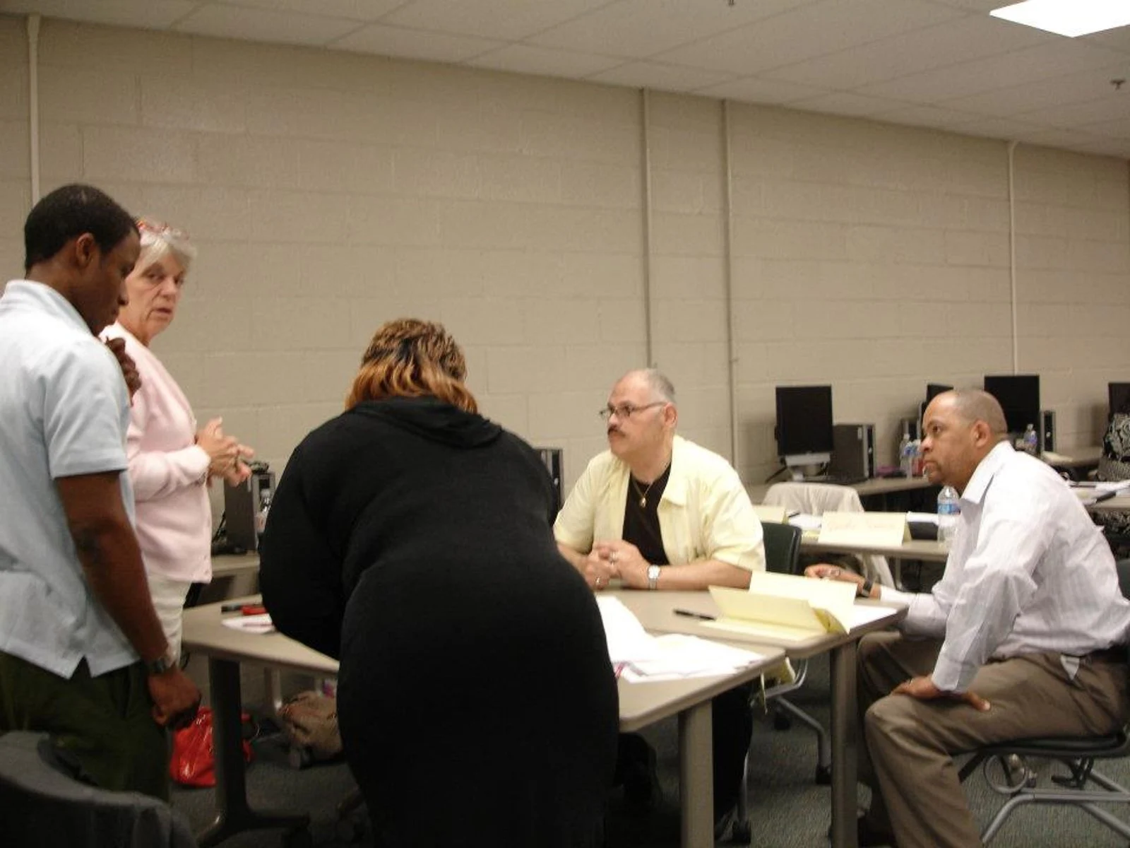 Photo of an Asian man holding a mobile phone in front of his with a white version of the Lloyds Banking Group logo superimposed in the middle foreground