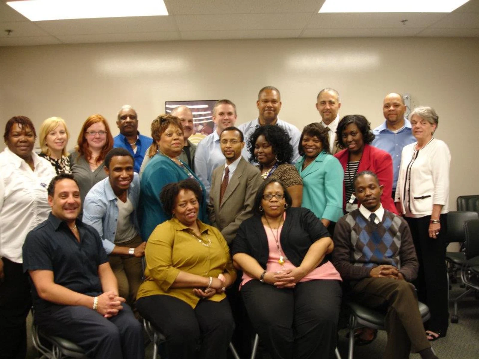 Photo of a group of people sat around a table eating pizza with a white version of the Coca Cola logo superimposed in the middle foreground